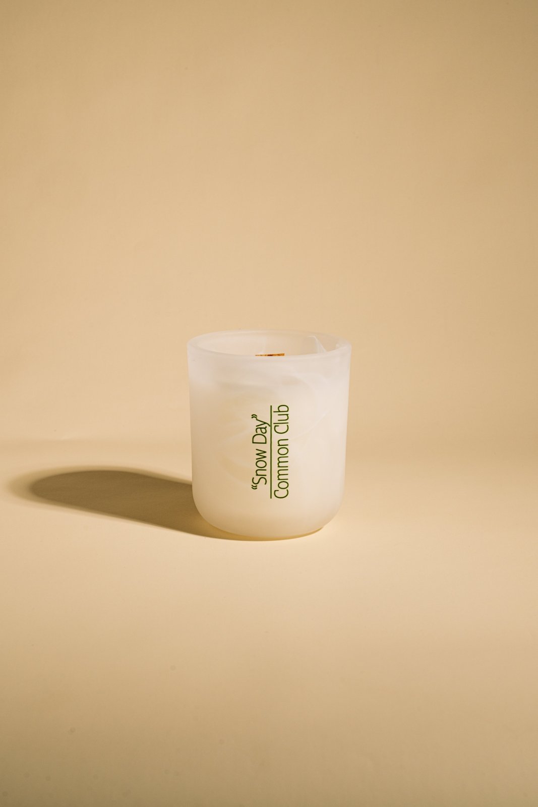 Candle with 'Snow Day Common Cup' text on a beige background
